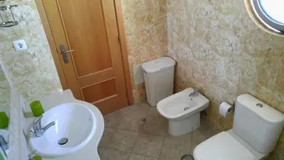 a bathroom with a white toilet and a sink at Olhos de Água Apartment Albufeira in Albufeira