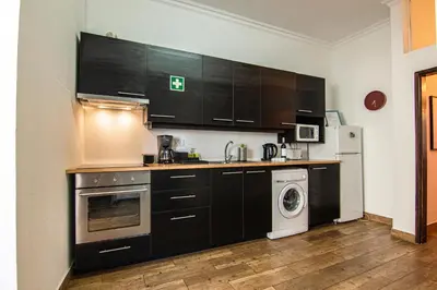 a kitchen with black cabinets and a washer and dryer at Faro Central - Holiday Apartments in Faro