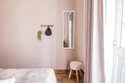 a bedroom with a bed and a mirror and a chair at Faro Central - Holiday Apartments in Faro