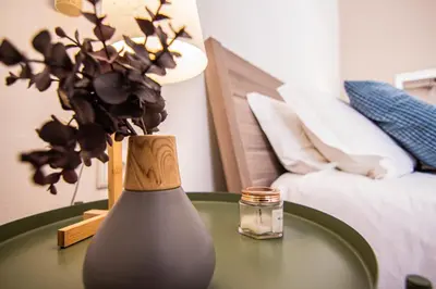 a table with a vase on a table with a bed at Faro Central - Holiday Apartments in Faro