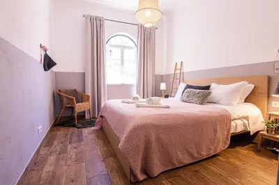 a bedroom with a large bed and a window at Faro Central - Holiday Apartments in Faro