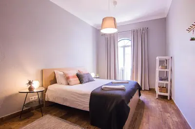 a bedroom with a bed and a table in it at Faro Central - Holiday Apartments in Faro