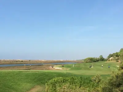a group of golfers on a green next to a river at Quinta do Lago Golf in Quinta do Lago