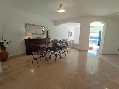 a dining room with a table and chairs on a tile floor at Vila Magna near The Strip with BBQ, AC, Balcony, Parking, 4 TVs and Free wifi in Albufeira