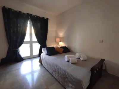 a bedroom with a bed with two towels on it at Vila Magna near The Strip with BBQ, AC, Balcony, Parking, 4 TVs and Free wifi in Albufeira