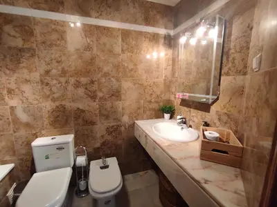 a bathroom with a sink and a toilet and a mirror at Vila Magna near The Strip with BBQ, AC, Balcony, Parking, 4 TVs and Free wifi in Albufeira
