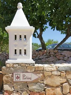 a building on top of a stone wall with a street sign at Retiro da Janela in Boliqueime