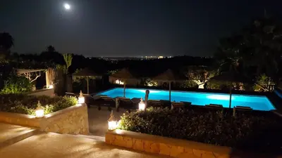 a swimming pool at night with lights at Retiro da Janela in Boliqueime