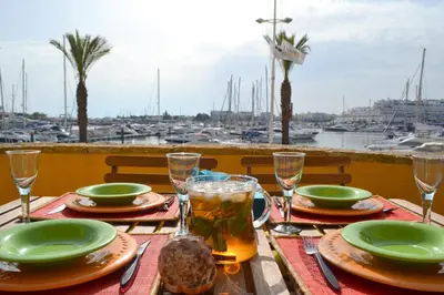 a table with plates of food and drinks and a marina at TP Coral 1 - Marina Vilamoura Apartment in Vilamoura