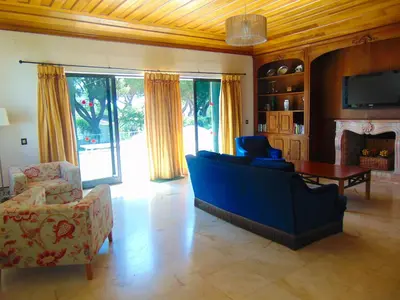 a living room with a blue couch and chairs at Vila Ninita in Vilamoura