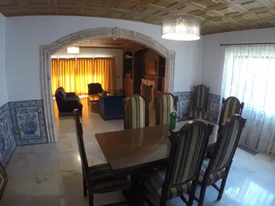 a dining room with a wooden table and chairs at Vila Ninita in Vilamoura