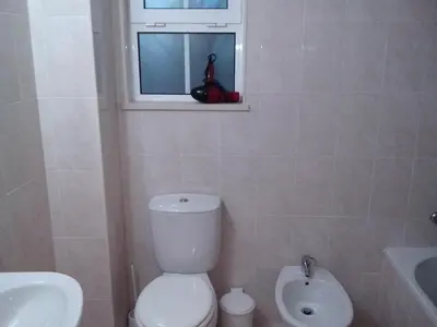 a bathroom with a toilet and a sink and a window at Deluxe Apartment E in Albufeira