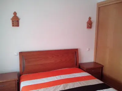 a bedroom with a bed with a red and white striped blanket at Deluxe Apartment H in Albufeira
