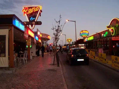 a city street with many neon signs and a car at Deluxe Apartment H in Albufeira