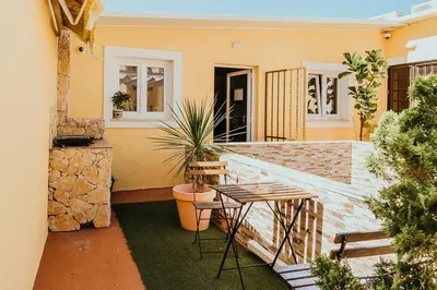 a patio with a table and chairs in a house at Happy House in Faro
