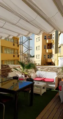 a patio with couches and tables on a building at Happy House in Faro