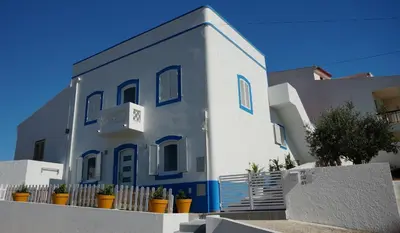 a blue and white building with plants in front of it at Golden Cliff House in Albufeira