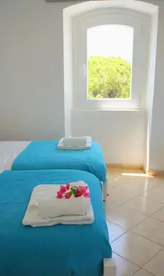 a bedroom with two beds with towels and a window at Golden Cliff House in Albufeira