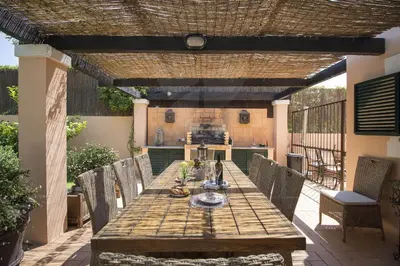 an outdoor dining room with a wooden table and chairs at Rubi in Vilamoura