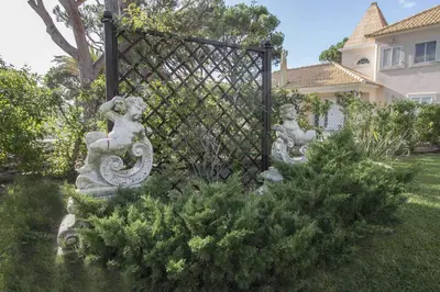a gate with two statues in a yard at Rubi in Vilamoura