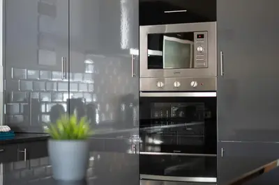 a kitchen with a stainless steel oven and microwave at Casa no Sol in Loulé