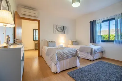 a bedroom with two beds and a window at Casa no Sol in Loulé