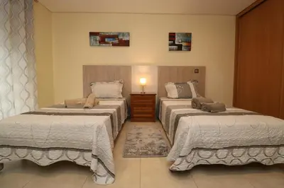 a bedroom with two beds and a lamp on a table at Alsol in Quarteira