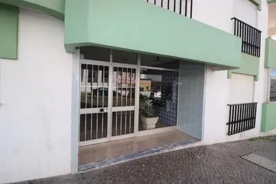 a building with glass doors and a green awning at Alsol in Quarteira