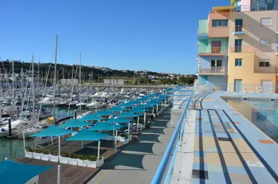 a marina with tables and umbrellas and boats at Penthouse Marina in Albufeira