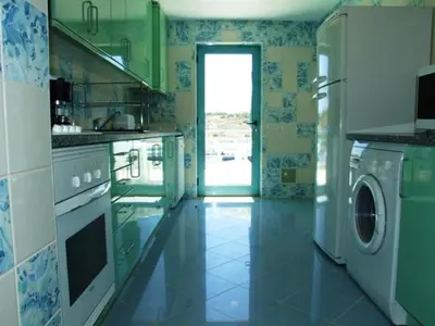 a kitchen with a washer and dryer in it at Penthouse Marina in Albufeira