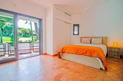 a bedroom with a bed and a large window at Villa Beira Golf in Quarteira