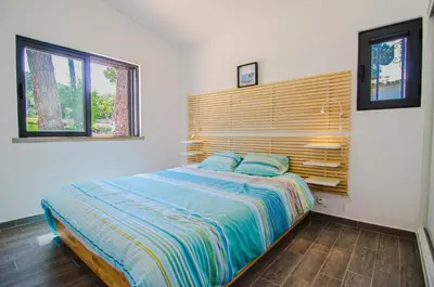 a bedroom with a bed with a wooden headboard at Villa Beira Golf in Quarteira