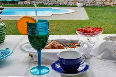 a table with a plate of food and a drink at 3 Villas - Praia da Falesia in Albufeira