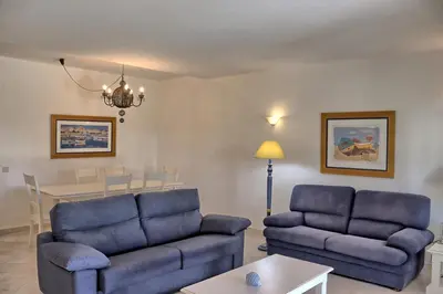 a living room with two blue couches and a table at Villa V2 Duplex - Vilamoura Tennis in Quarteira
