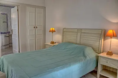 a bedroom with a bed and two lamps on tables at Villa V2 Duplex - Vilamoura Tennis in Quarteira