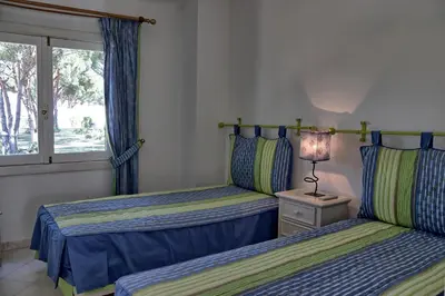 two beds in a room with a window and a lamp at Villa V2 Duplex - Vilamoura Tennis in Quarteira