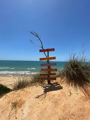 a sign on a beach with the ocean in the background at Algarve Vacations Flat in Albufeira
