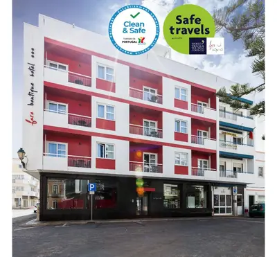 a red and white building with a sign that reads gate travels at Faro Boutique Hotel in Faro