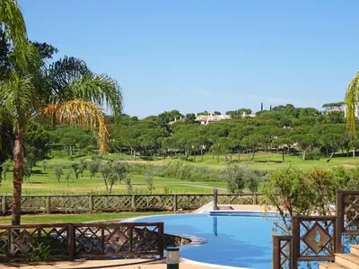 a dining room with a wooden table and chairs at Formosa Villas in Quinta do Lago
