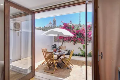 a table with an umbrella and chairs on a patio at Casa da Avó in Faro