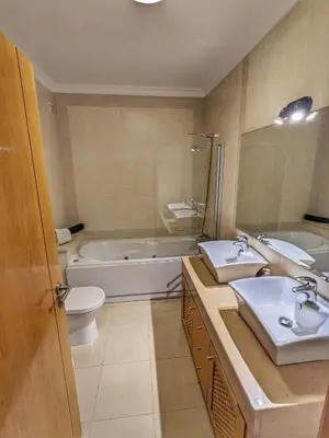 a bathroom with two sinks and a tub and a toilet at Farm Village- Townhouse 2 mins from Old Town Albufeira in Albufeira