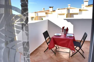 a table and chairs on a balcony with a white wall at Farm Village- Townhouse 2 mins from Old Town Albufeira in Albufeira
