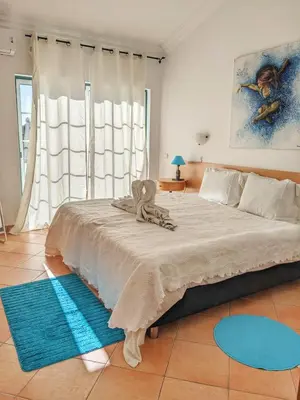 a bedroom with a large bed with blue rugs at Townhouse 700m from Sao Rafael Beach in Albufeira