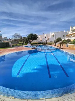 a large swimming pool with blue water at Townhouse 700m from Sao Rafael Beach in Albufeira