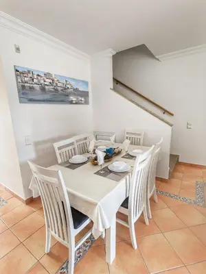 a dining room with a white table and chairs at Townhouse 700m from Sao Rafael Beach in Albufeira