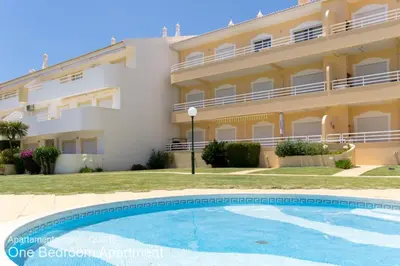 a villa with a swimming pool in front of a building at Akisol Vilamoura Sun III in Vilamoura
