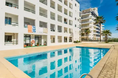 a swimming pool in front of a building at Akisol Quarteira Sunny in Quarteira