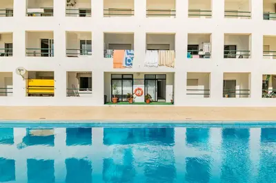 an external view of a building with a swimming pool at Akisol Quarteira Sunny in Quarteira