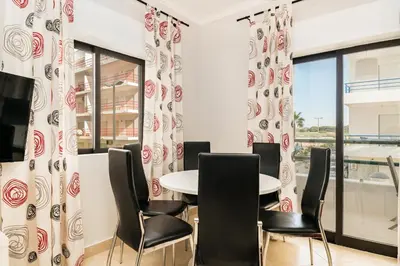 a dining room with a table and chairs at Akisol Quarteira Sunny in Quarteira