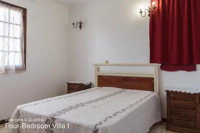 a bedroom with a bed and a red curtain at Akivillas Quarteira Rose in Quarteira